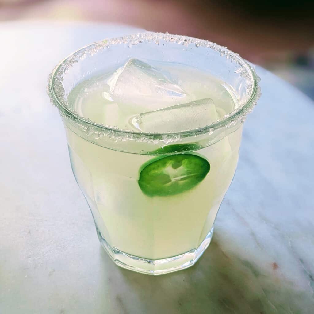 Mezcal Margarita in a glass with a jalapeño slice